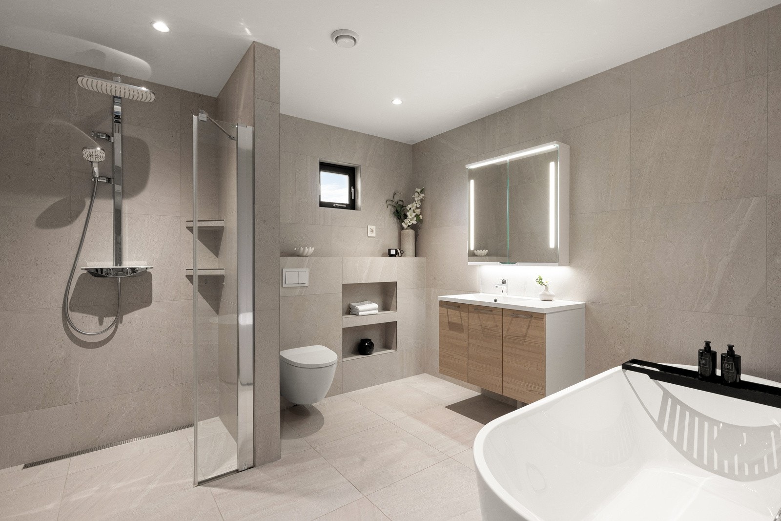 Innholdsrikt bad med 60x60 fliser på gulv og vegger, samt downlights i himling. Badet er også utstyrt med balansert ventilasjon og installert vindu for naturlig lys. Galleribilde