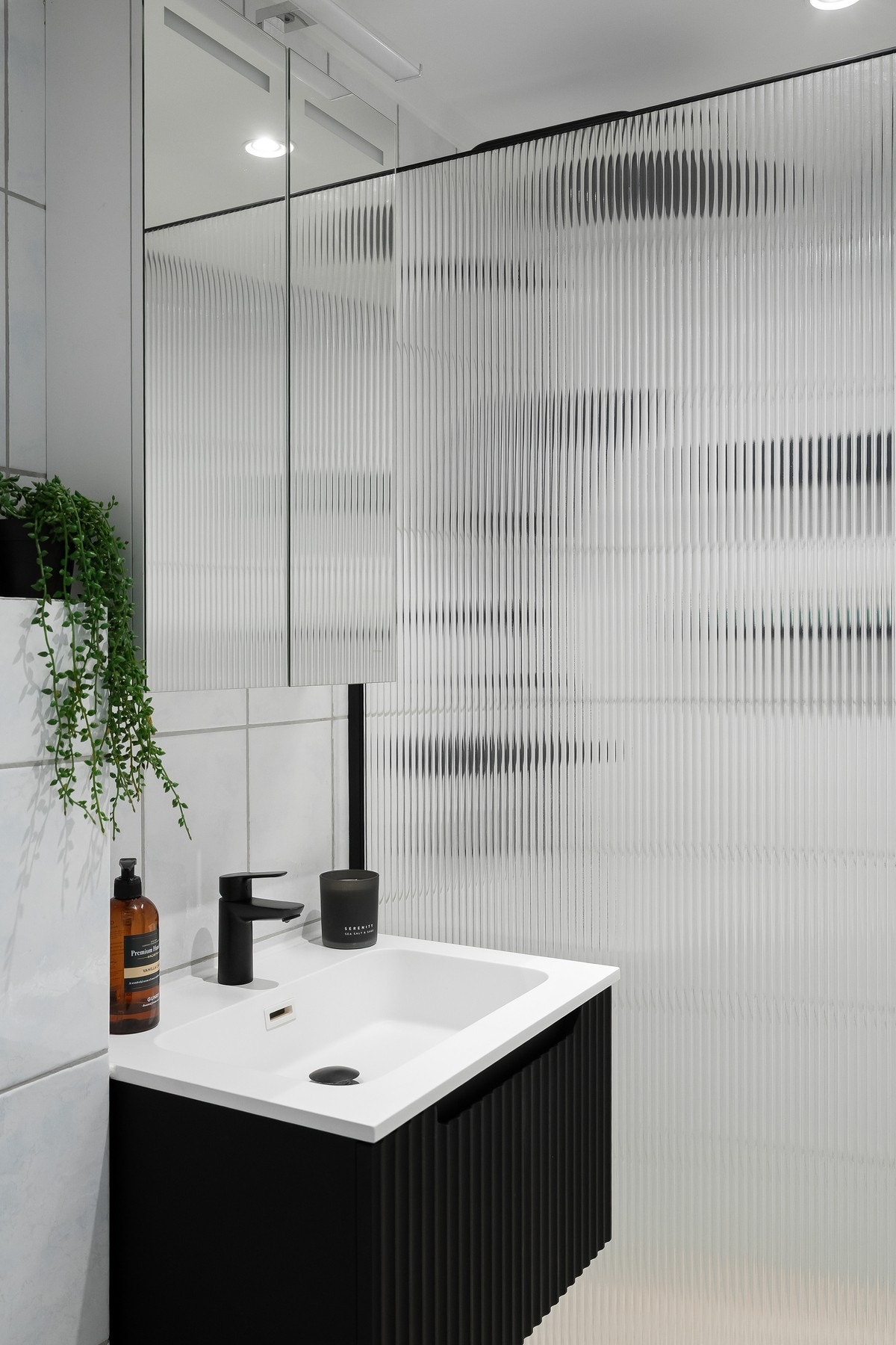 Stilren baderomsinnredning med vegghengt servant og speilskap med integrert belysning over Galleribilde