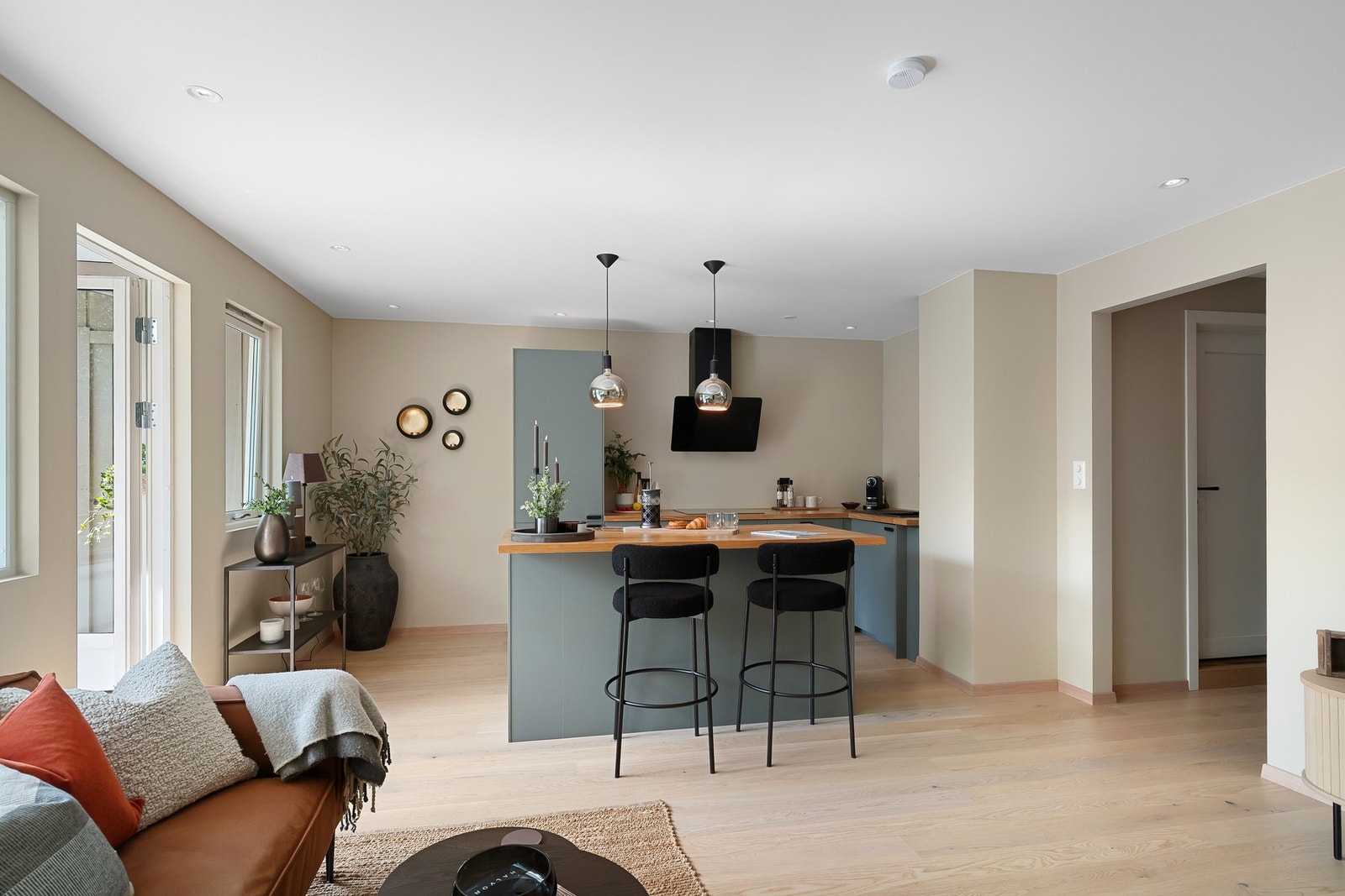 Kjøkkeninnredning i tidsriktige farger som går godt mot de lyse overflatene i rommet Galleribilde