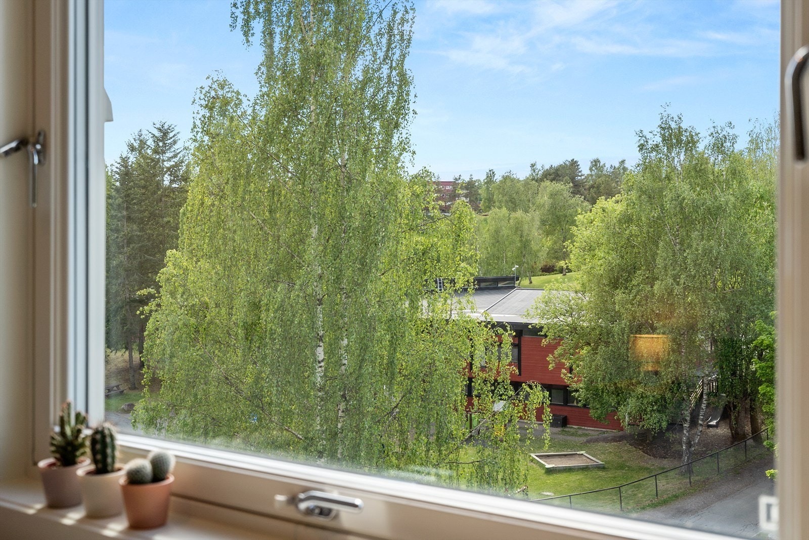 Utsikt til grønne omgivelser fra soveromsvinduet. Galleribilde