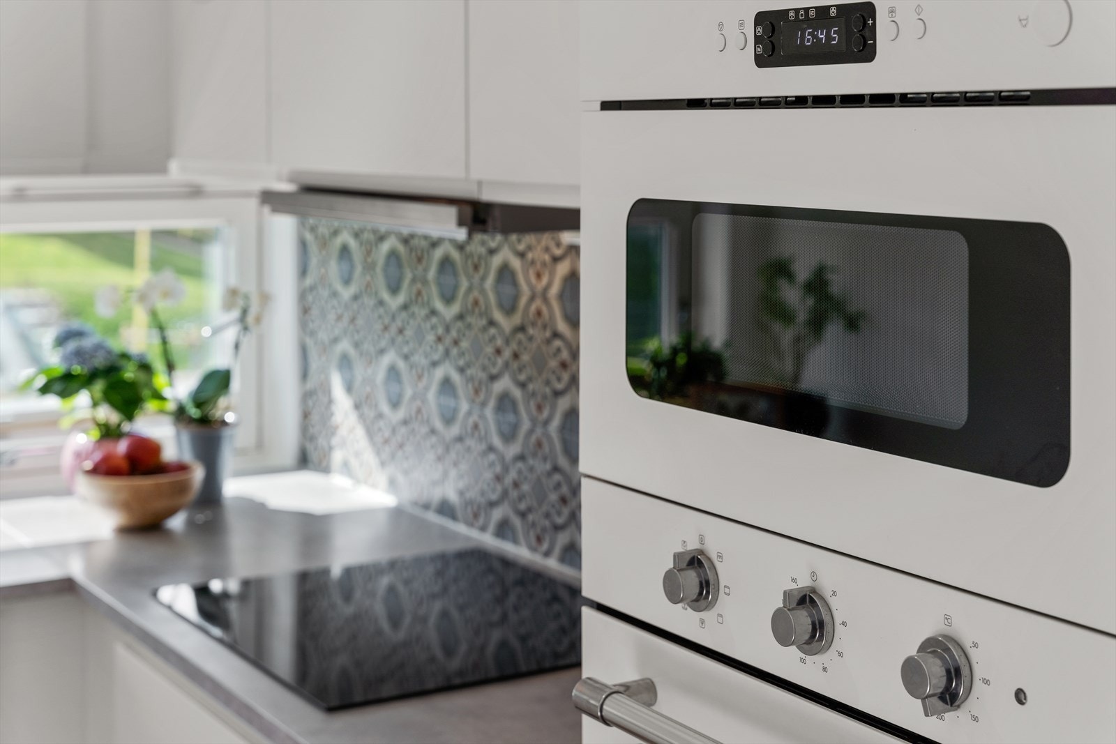 Kjøkkenet har integrerte hvitevarer og frittstående kjøleskap Galleribilde