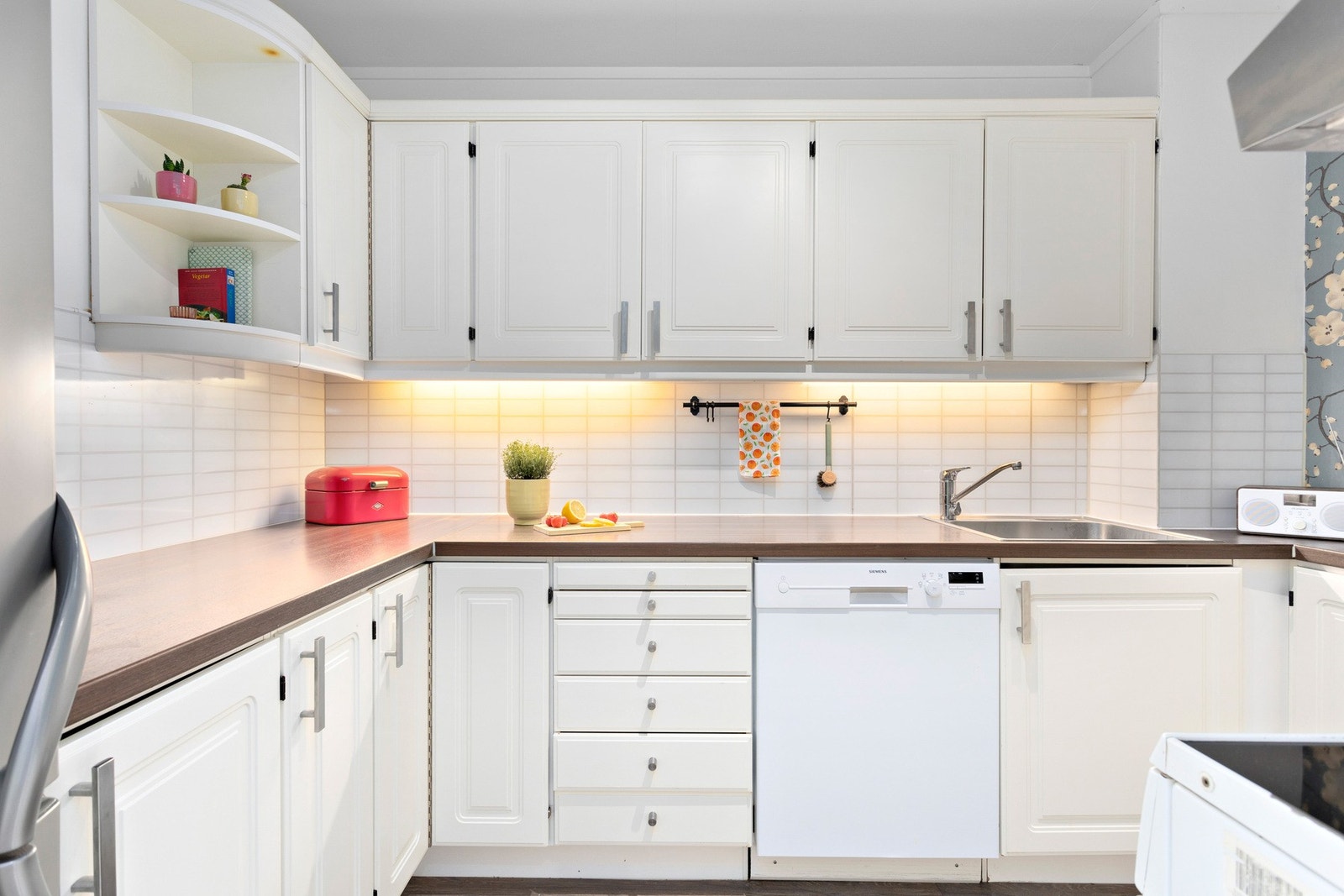 Kjøkkeninnredning med profilerte fronter, overskap med belysning under og ventilator
med kullfilter Galleribilde