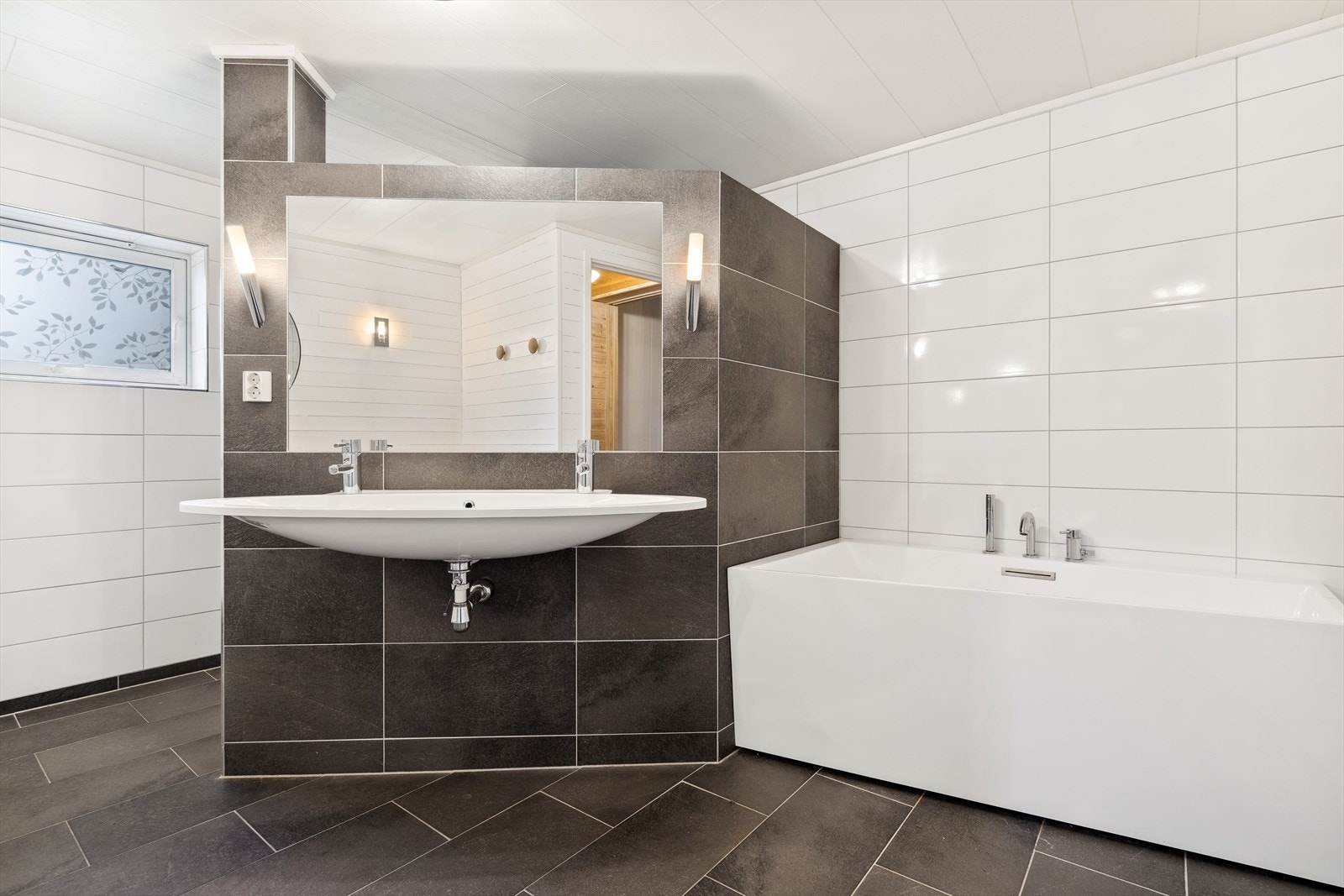 Badet nede er romslig og har både badekar og dusjhjørne samt badromrinnredning Galleribilde
