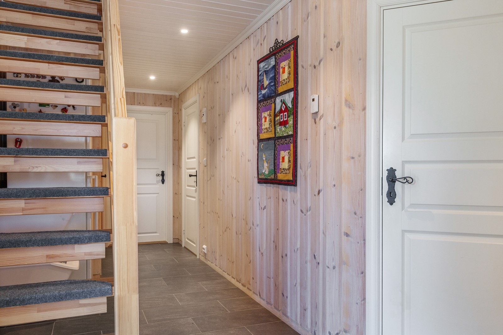 Fritidsboligen har lakkert tretrapp med rekkverk, adkomst fra gang til oppstue. Galleribilde