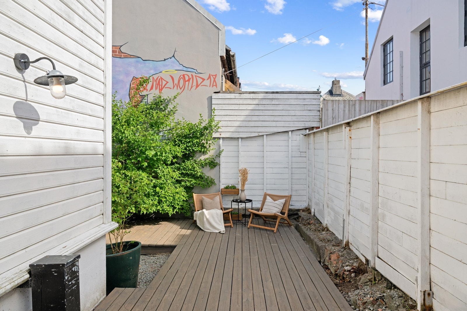 Bakgården er livlig med dekorativ murkunst, og mye beplantning Galleribilde