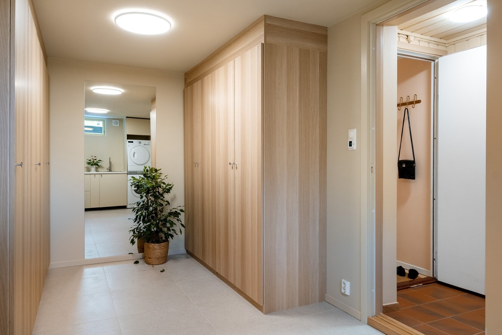 Lys og hyggelig garderobe i samband med vaskerommet. I garderoben er det god plass til å henge og sette fra seg yttertøy, innredet med store garderobeskap. Galleribilde