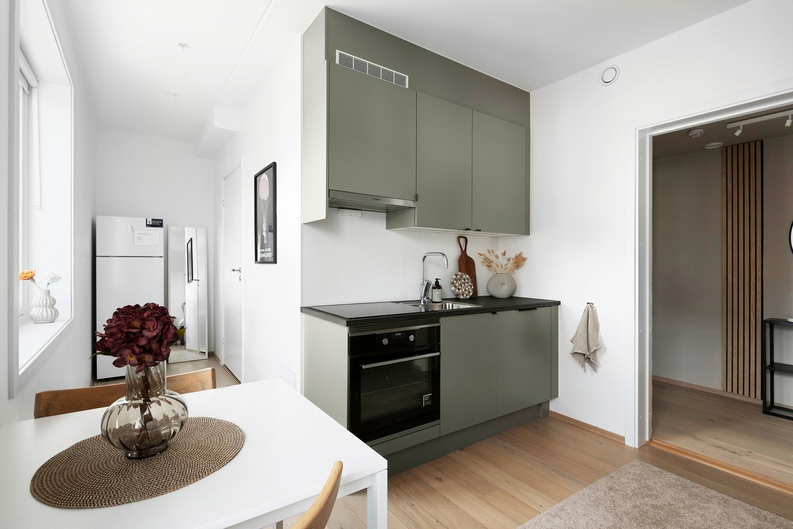 Her er et praktisk kjøkken med integrerte hvitevarer, foruten kjøleskap (god plass til et plass til frittstående) Galleribilde