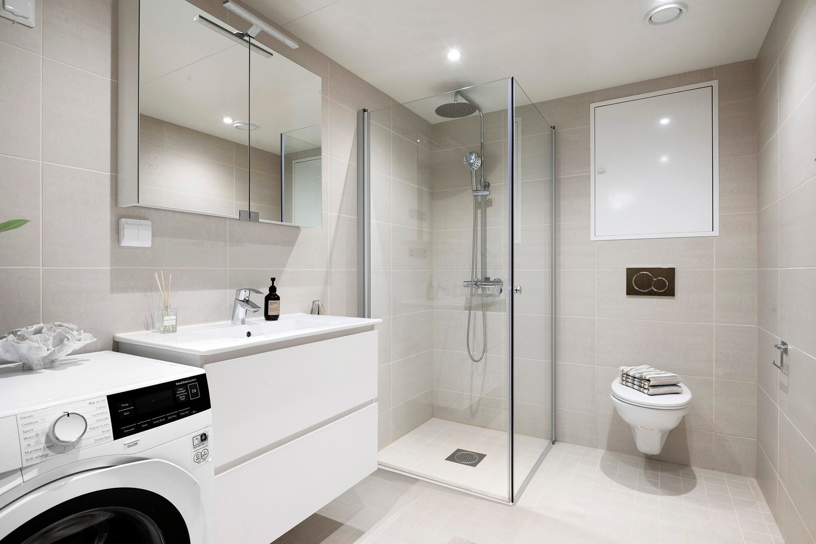 Leiligheten har et lekkert, helfliset baderom med varme i gulv og downlights i himling Galleribilde