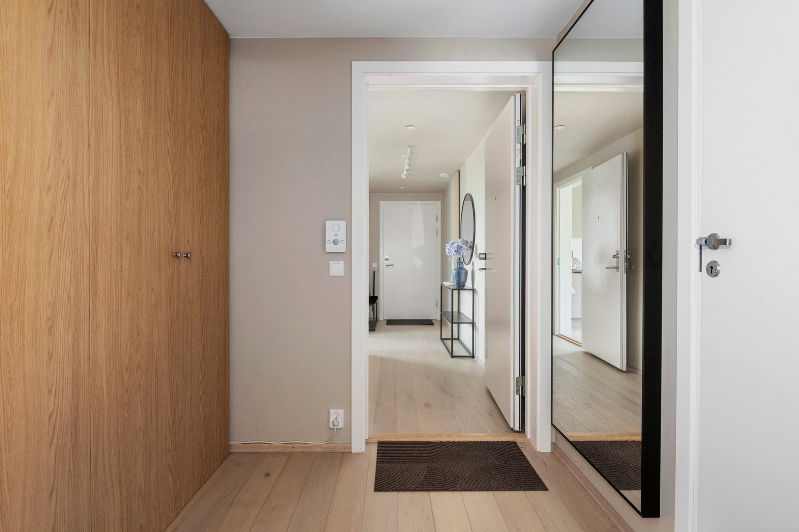 Videre inn i hovedleiligheten kommer man til en lys og innbydende gang med et større garderobeskap hvor en enkelt kan oppbevare både yttertøy og sko Galleribilde