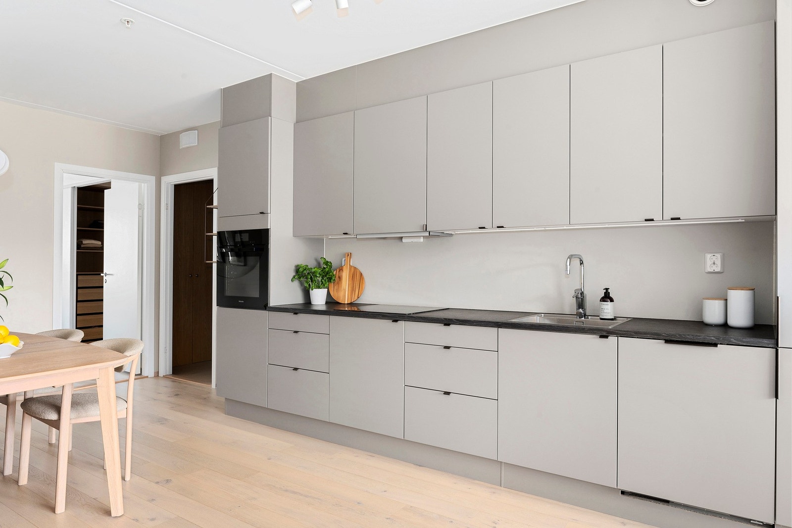 Leiligheten har et lekkert og stilrent kjøkken fra HTH med slette fronter i en beige farge og laminat benkeplate Galleribilde