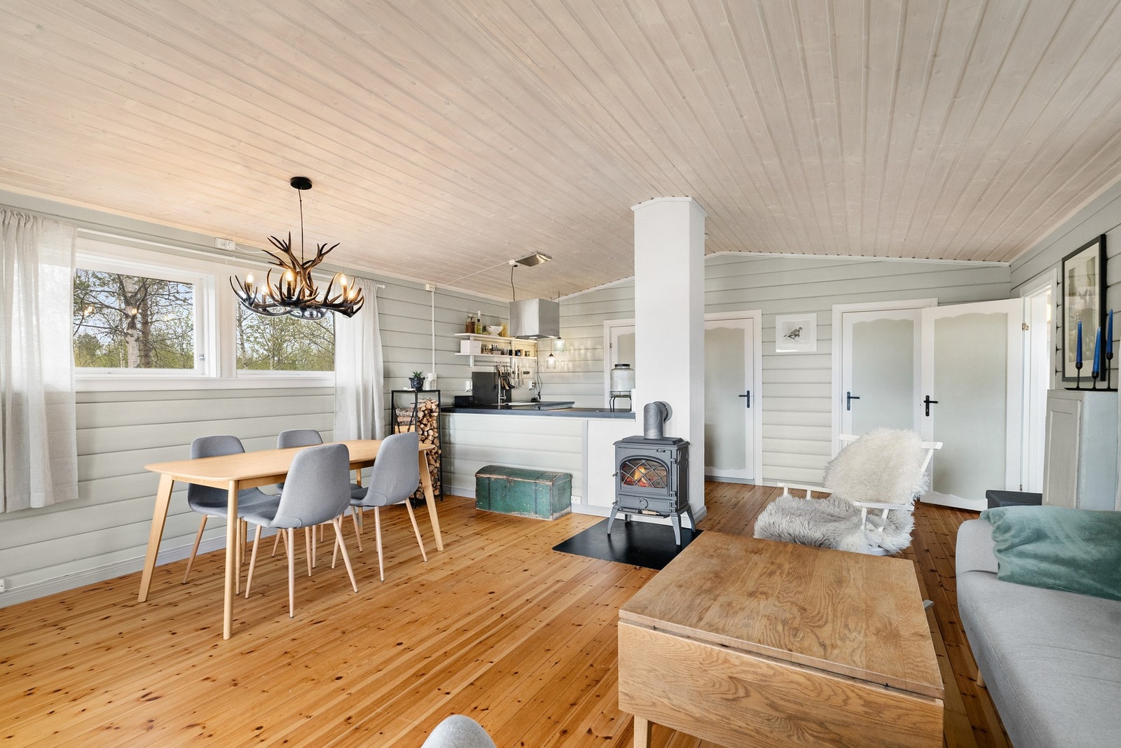 Stuen har tregulv og lysmalte vegger med trepanel. Galleribilde