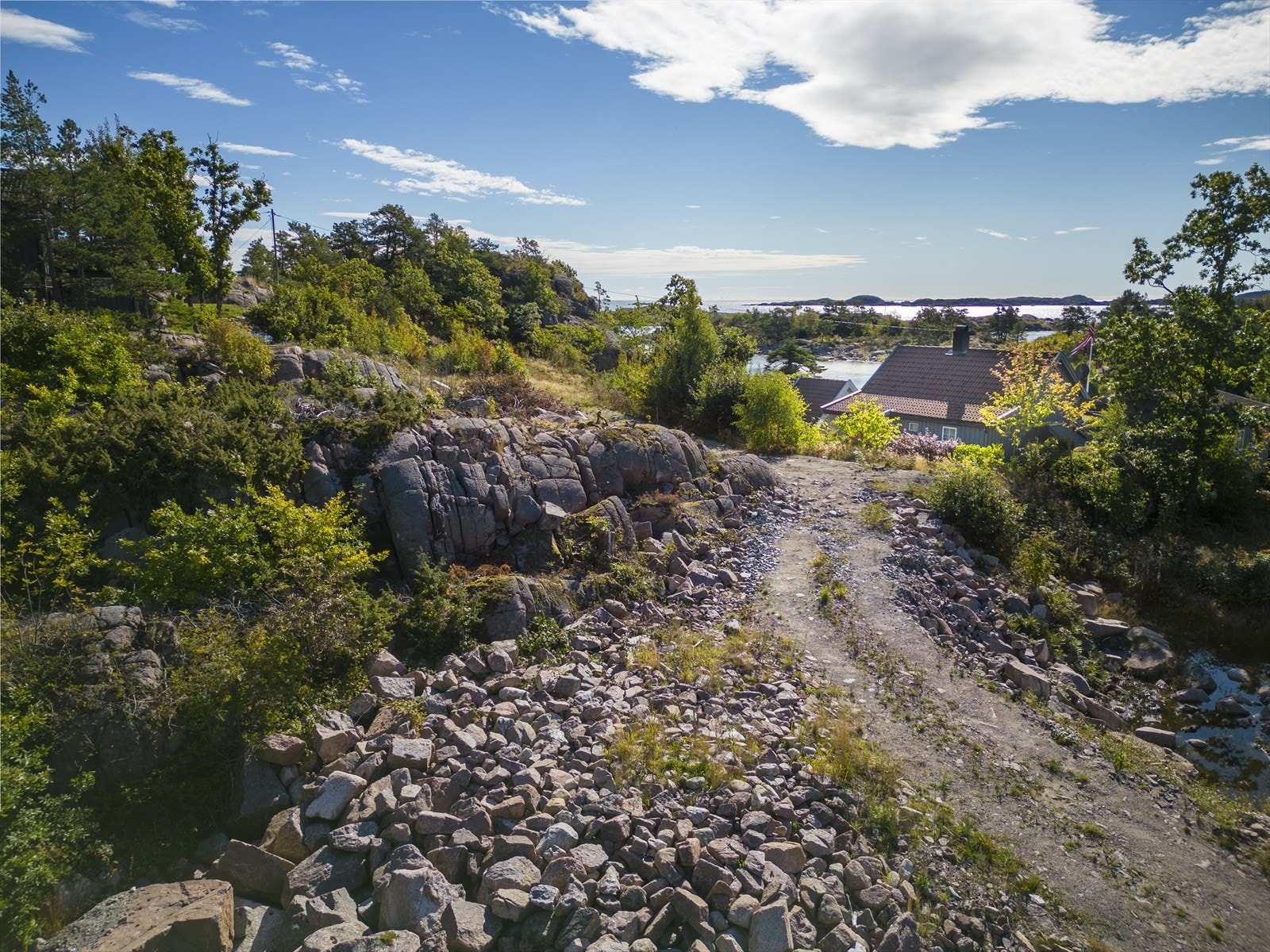 Det er kjørevei og parkering til tomten. Galleribilde