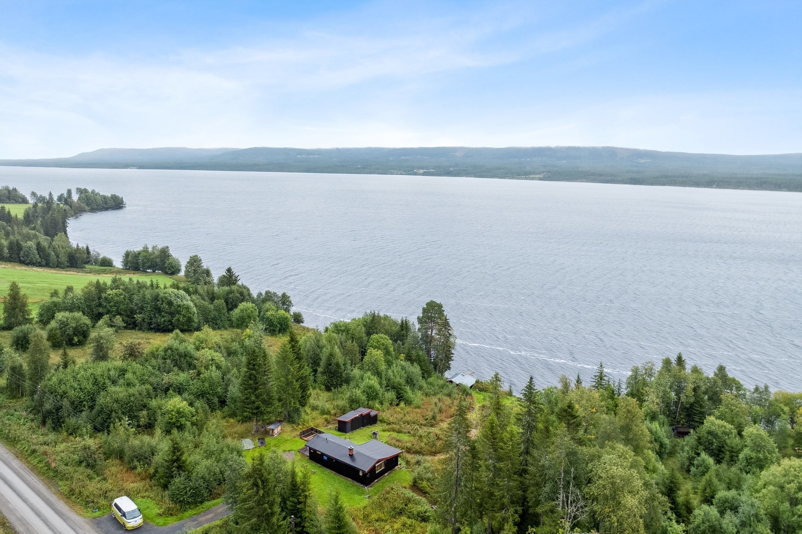 Skrånet østvendt eiet tomt med båthus, brygge og strandlinje. Galleribilde
