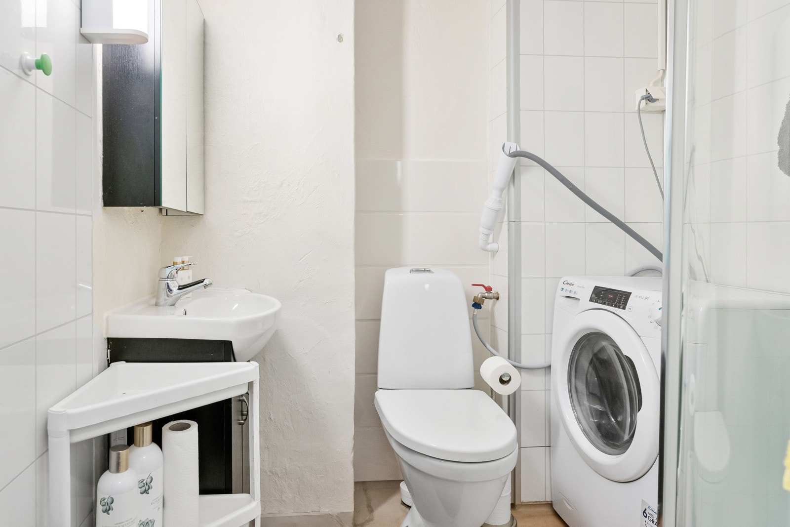 Bad innredet med servant, dusjkabinett og WC med opplegg for vaskemaskin Galleribilde