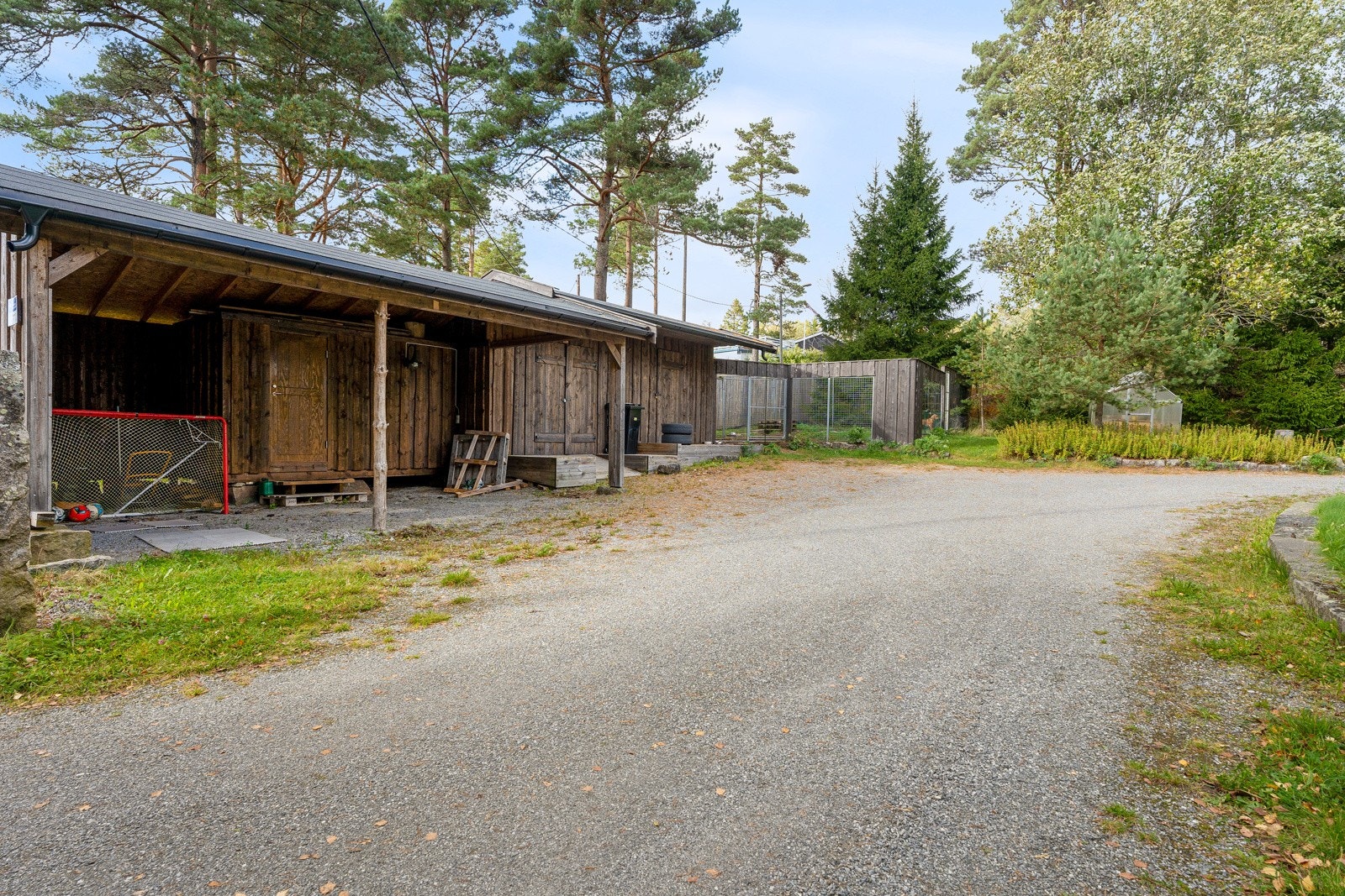 Carport, isolert verksted, lagringsrom med innkjøringsrampe, hunderom med 2 isolerte innvendige hundehus og todelt hundegård. Galleribilde