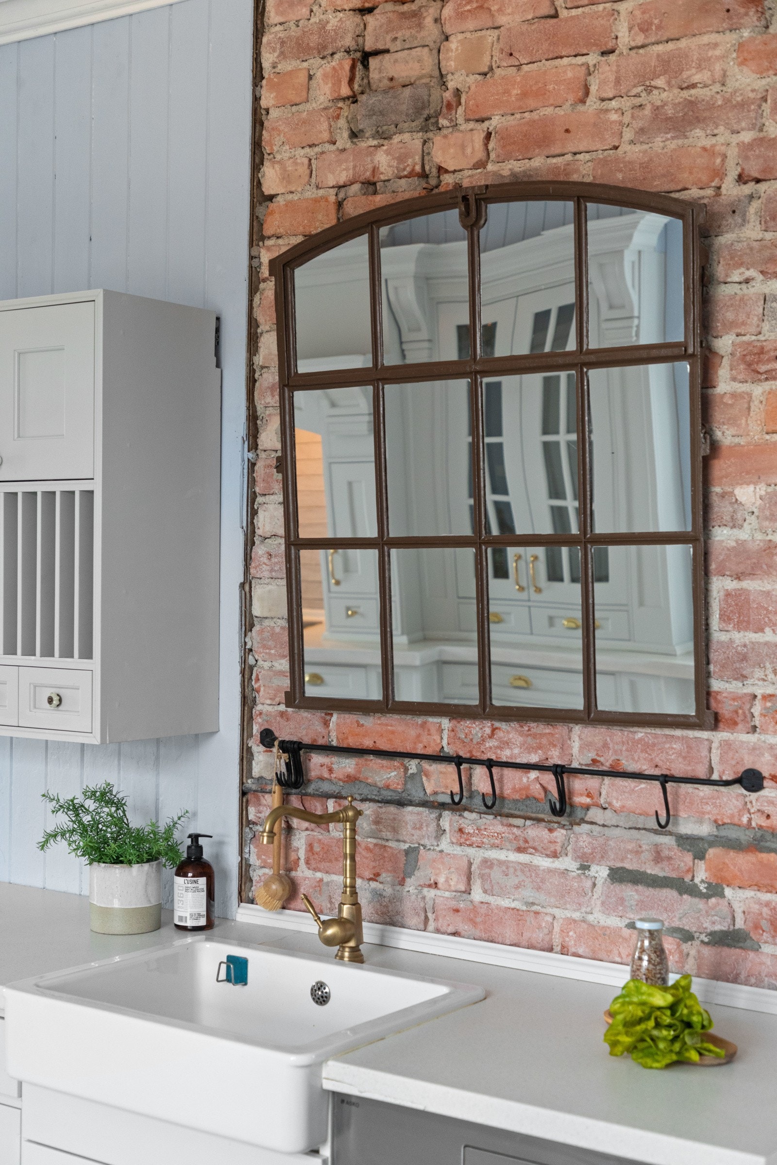 Veggen bak porselensvasken er kledd i rød teglstein, i vakker kontrast til alt det lyse. Galleribilde