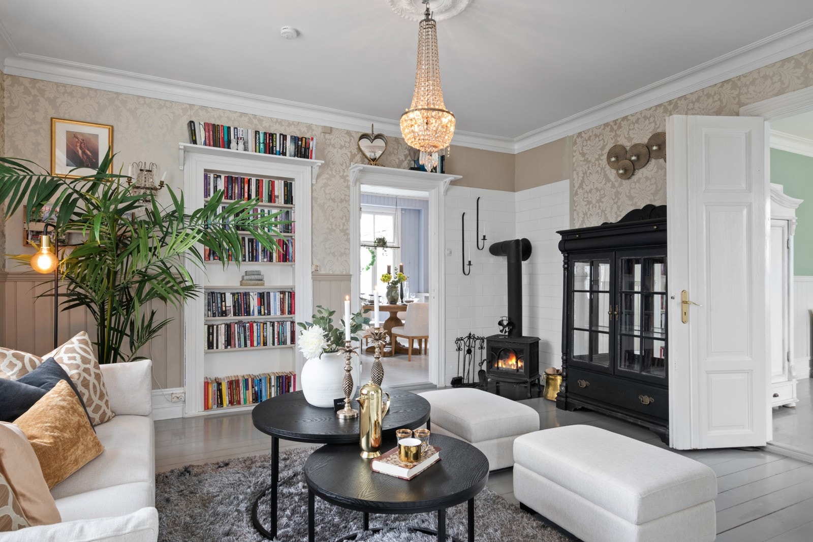 Med både vedovn og varmepumpe får man det lunt og godt i stuen, og bak ildstedet er veggene kledd med hvite fliser. Galleribilde