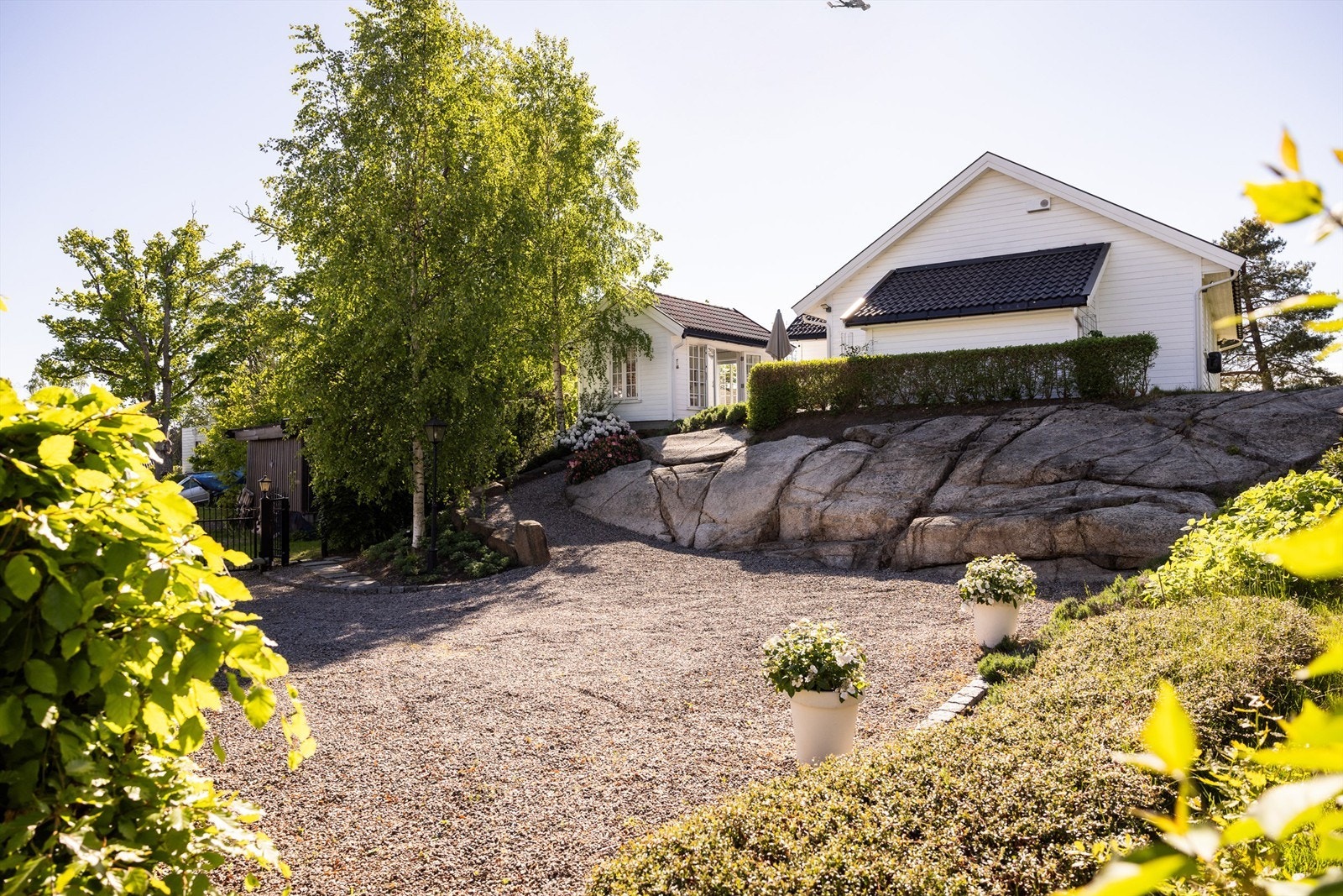 Videre er det et herskapelig preg over tunet med elektrisk bilport og gangport inn til den gruslagte gårdsplassen og den stemningsfulle stien opp til huset Galleribilde