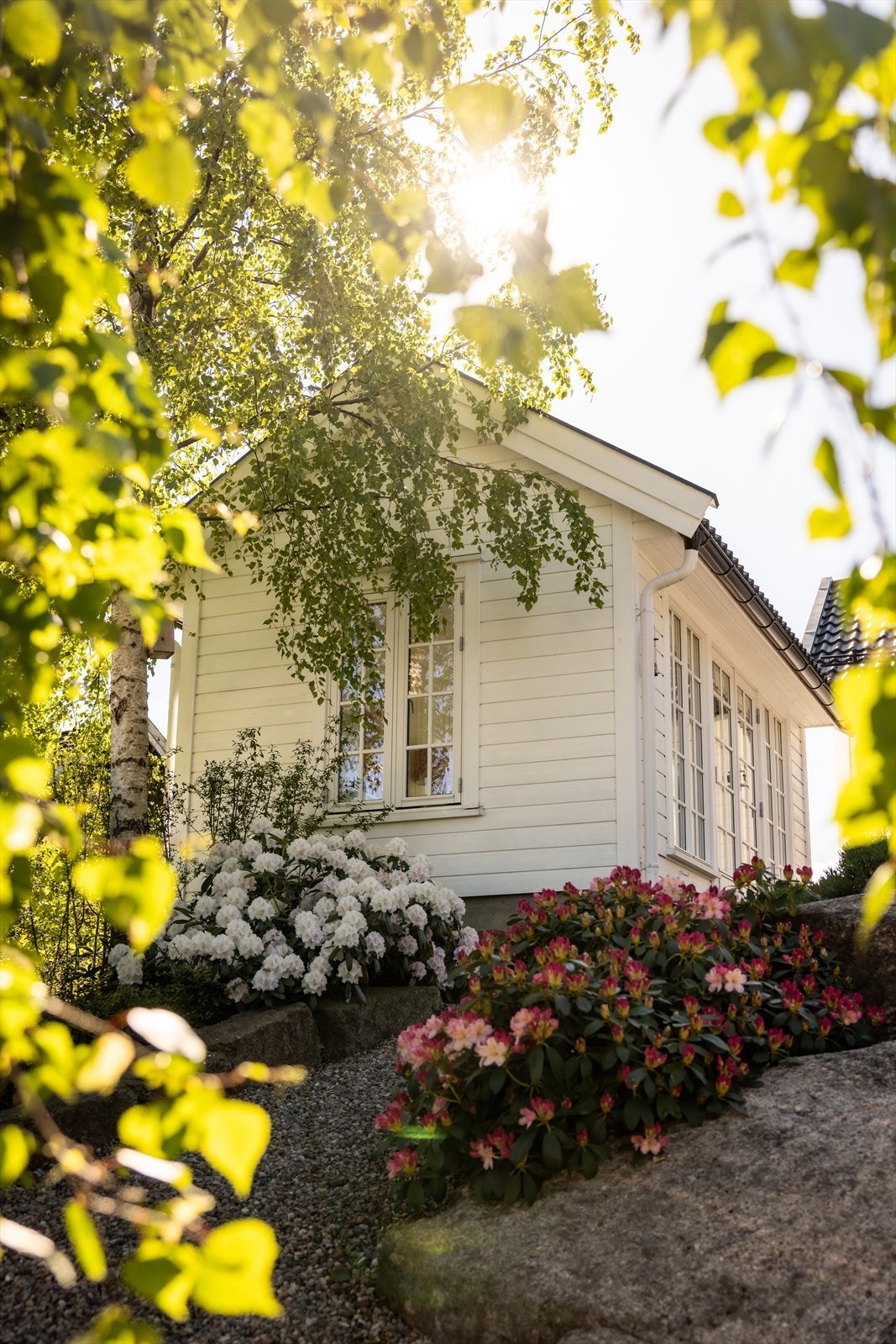 Hagen er vakkert opparbeidet med gruset gangvei fra gårdsplassen, koselig plen, stemningsfulle bed og flott beplatning Galleribilde