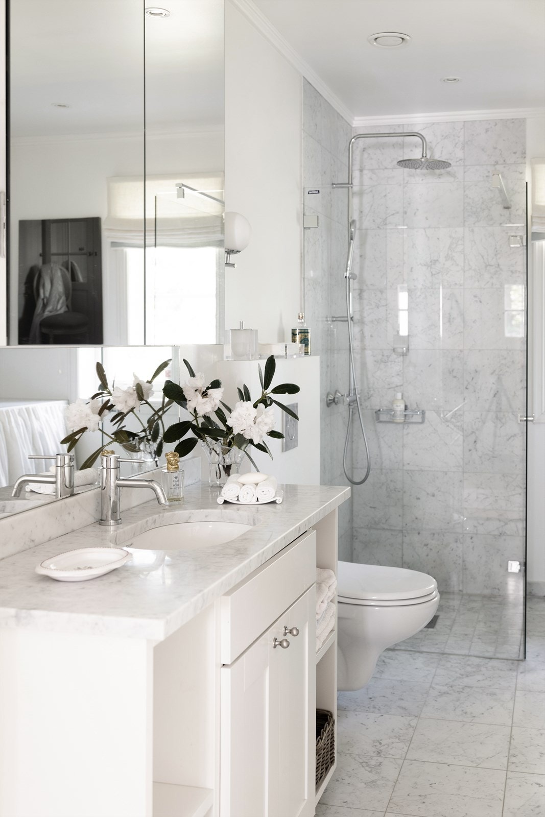 Deilikat baderom med marmorfliser på gulv og vegger i dusjsonen, samt varmekabler i gulv Galleribilde