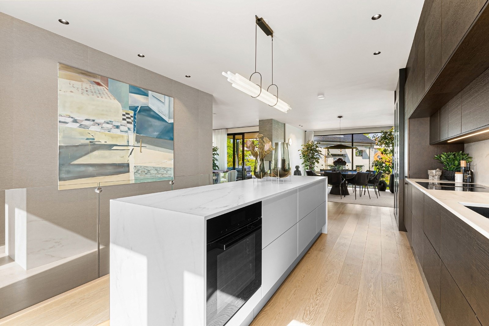 Innredning med takhøye skap og fronter i beiset eik. Dekton benkeplate. Galleribilde