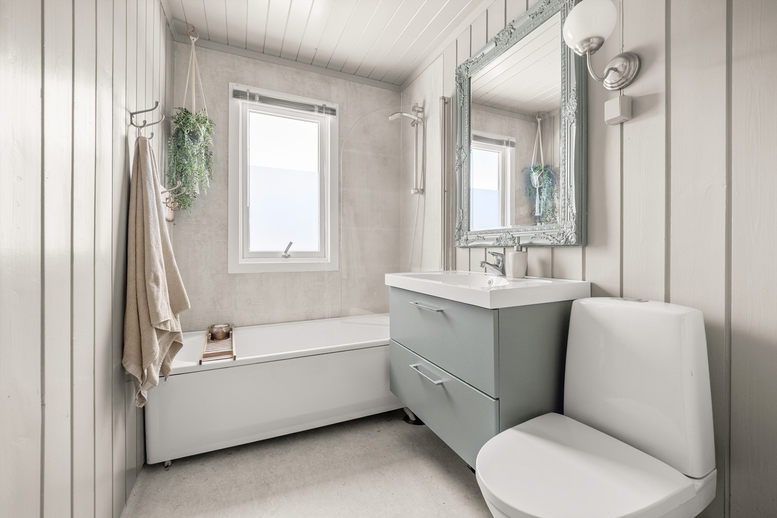 Boligens bad ligger i 1. etasje. Baderommet har en eldre utførelse. Det er lagt belegg på gulv, våtromsplater i dusjsonen og malt panel på øvrige veggflater samt i himling. Galleribilde