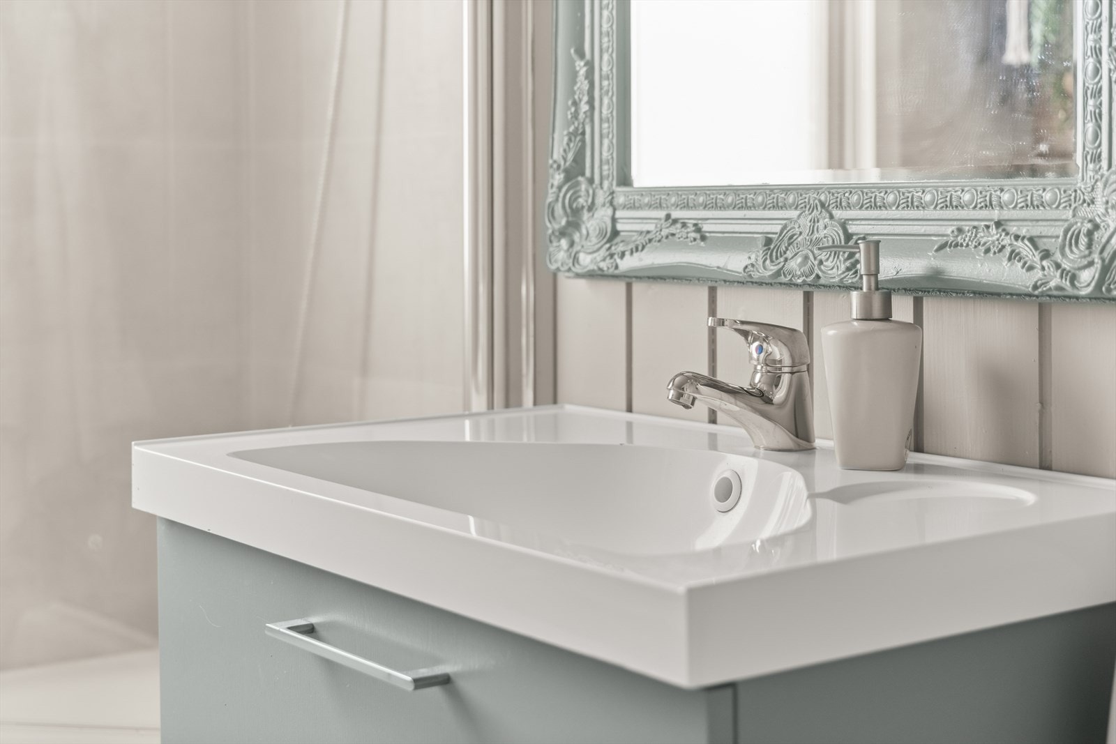 Rommet er innredet med badekar, gulvstående toalett og servantskap med skuffer. Det er montert speil og vegglampe. Galleribilde