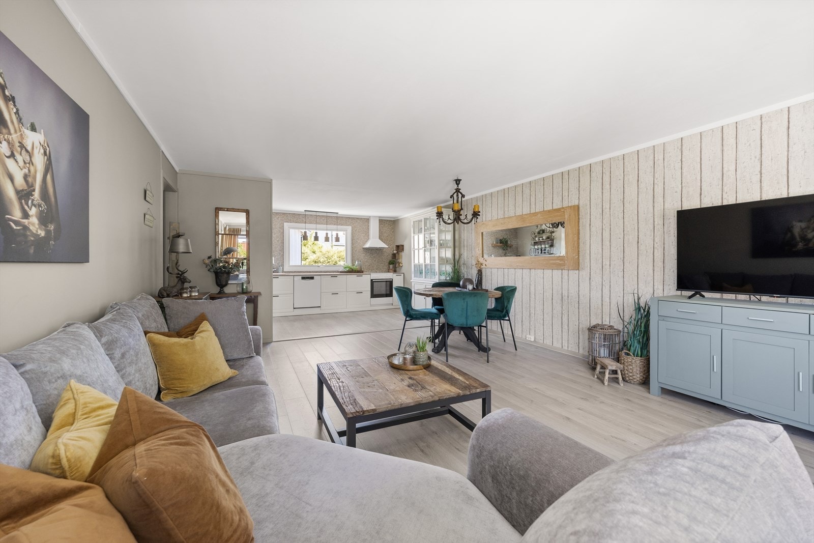 Rommet har god plass til både sofagruppe og stort spisebord, og den gjennomgående planløsningen gir en luftig og sosial atmosfære. Galleribilde