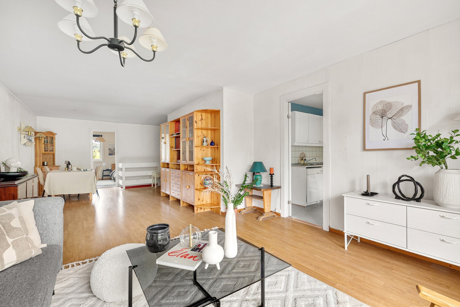 Stuen har gulv av laminatskjøter og lysmalte overflater Galleribilde