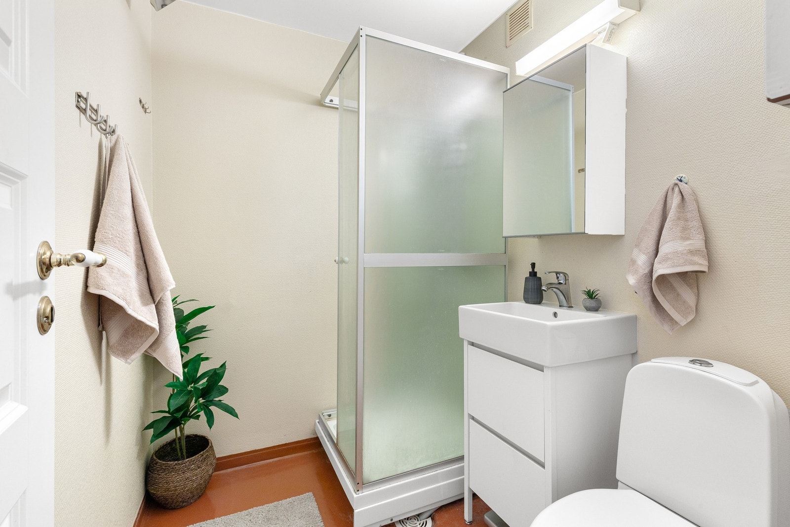 Enkel løsning med lys servantinnredning og speilskap over Galleribilde