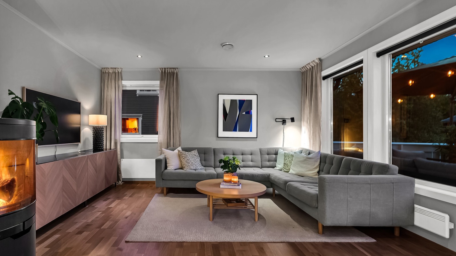 Peisovnen sprer en lun varme mens downlightsene i taket skaper en rolig og stemningsfull belysning. Galleribilde