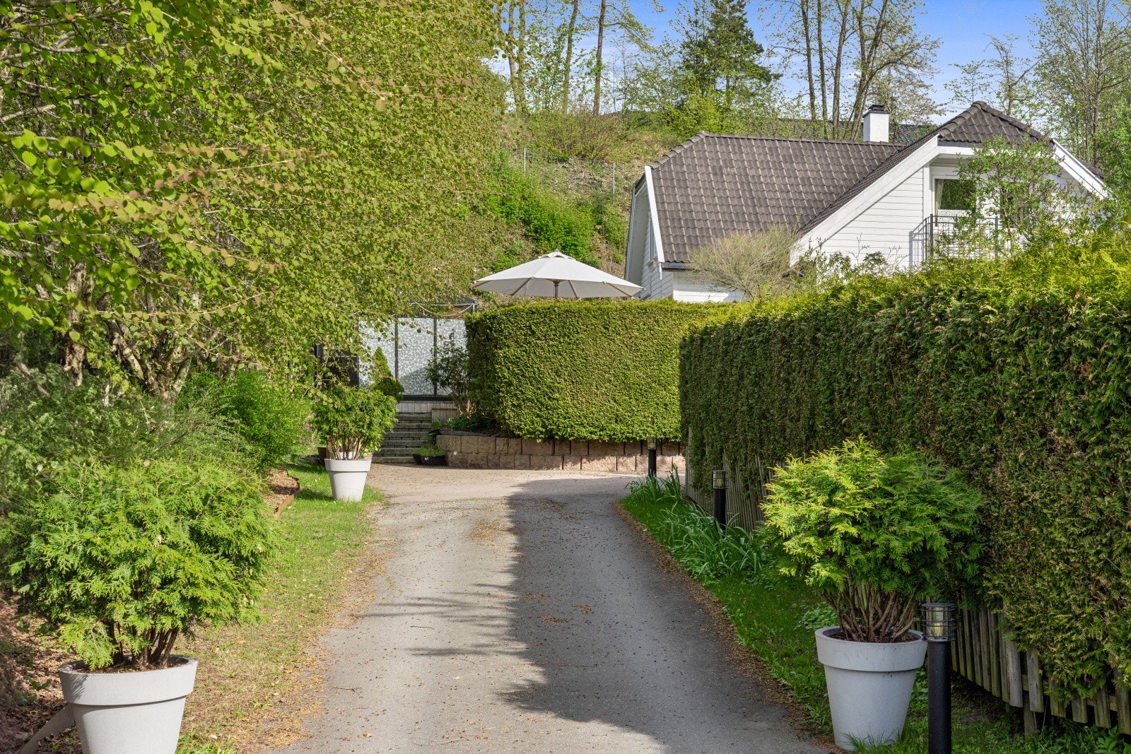 Asfaltert gårdsplass med egen innkjørsel, godt opplyst av nyere belysning. Galleribilde