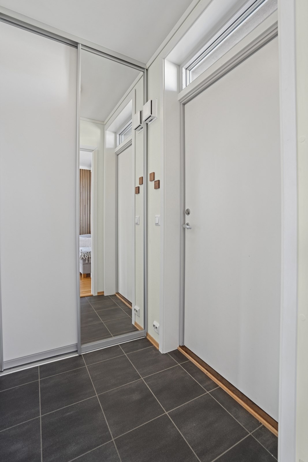 Du ønskes velkommen inn i en lys og innbydende entré med en praktisk skyvedørsgarderobe. Galleribilde