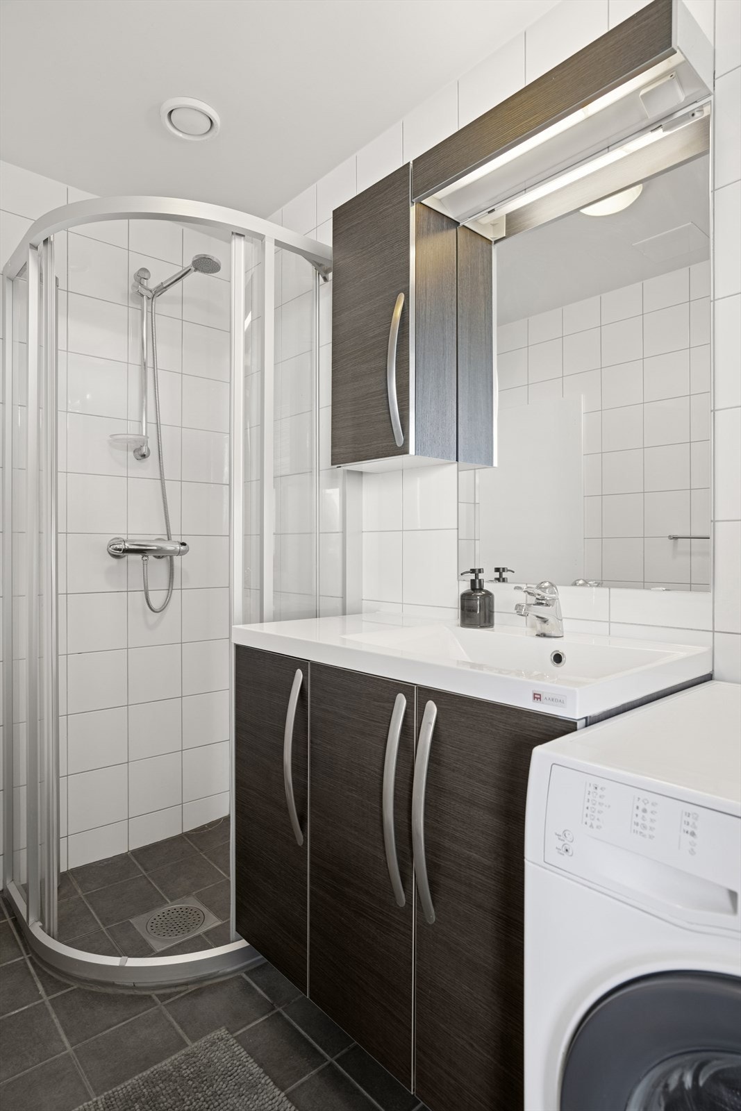 Videre er det et dusjhjørne og vegghengt toalett. Galleribilde