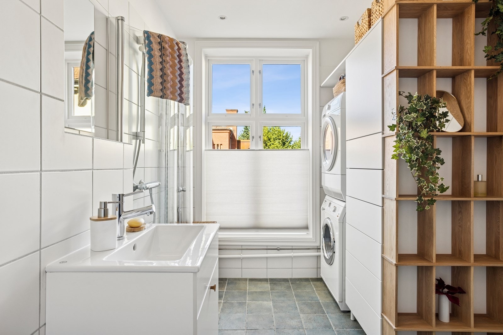 Deilig med vindu på badet! I 2020 ble det etablert en praktisk nisje med plass til både vaskemaskin og tørketrommel, i tillegg til smarte oppbevaringsløsninger. Galleribilde