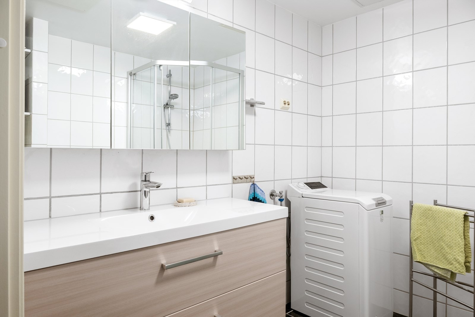 Bad/vaskerom med nyere servantmøbel og overskap Galleribilde