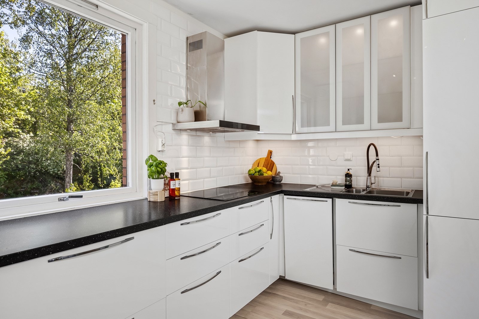 Kjøkkenet har en praktisk utforming og godt med skap- og benkeplass. Laminat benkeplate med nedfelt kum i rustfritt stål, kullfilterventilator over kokesone. Galleribilde