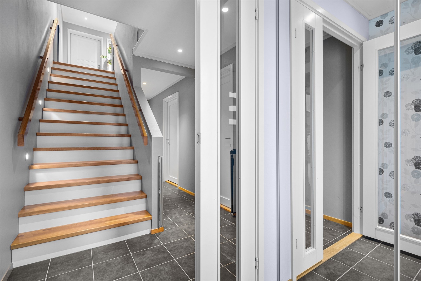 Innbydende entré. En praktisk skyvedørsgarderobe med speilfronter i vindfanget. Galleribilde