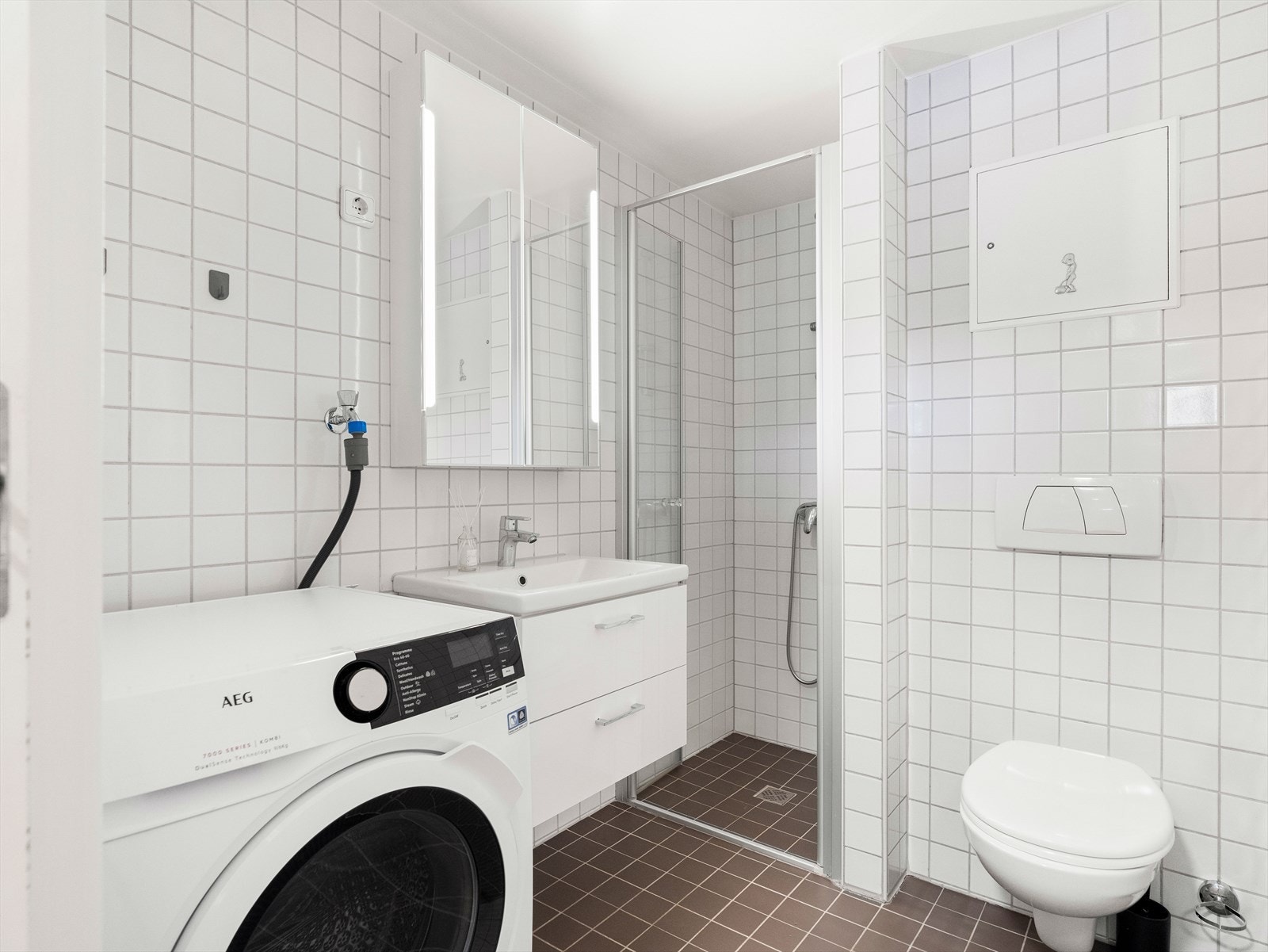 Badet har flislagte overflater, gulvvarme og god plass til vaskemaskin. Galleribilde