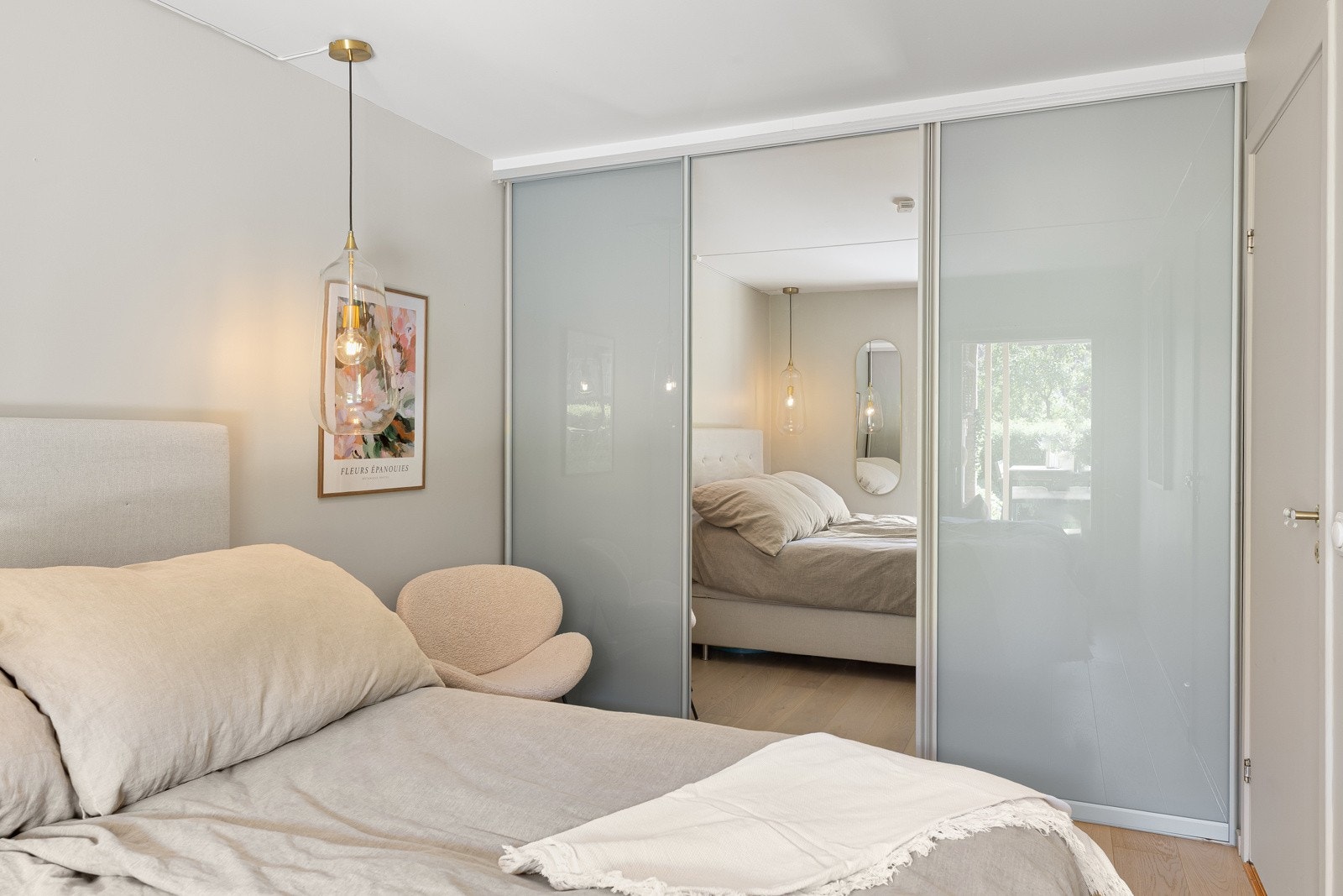 En hel vegg er dekket av en stor skyvedørsgarderobe med mye oppbevaringsplass Galleribilde