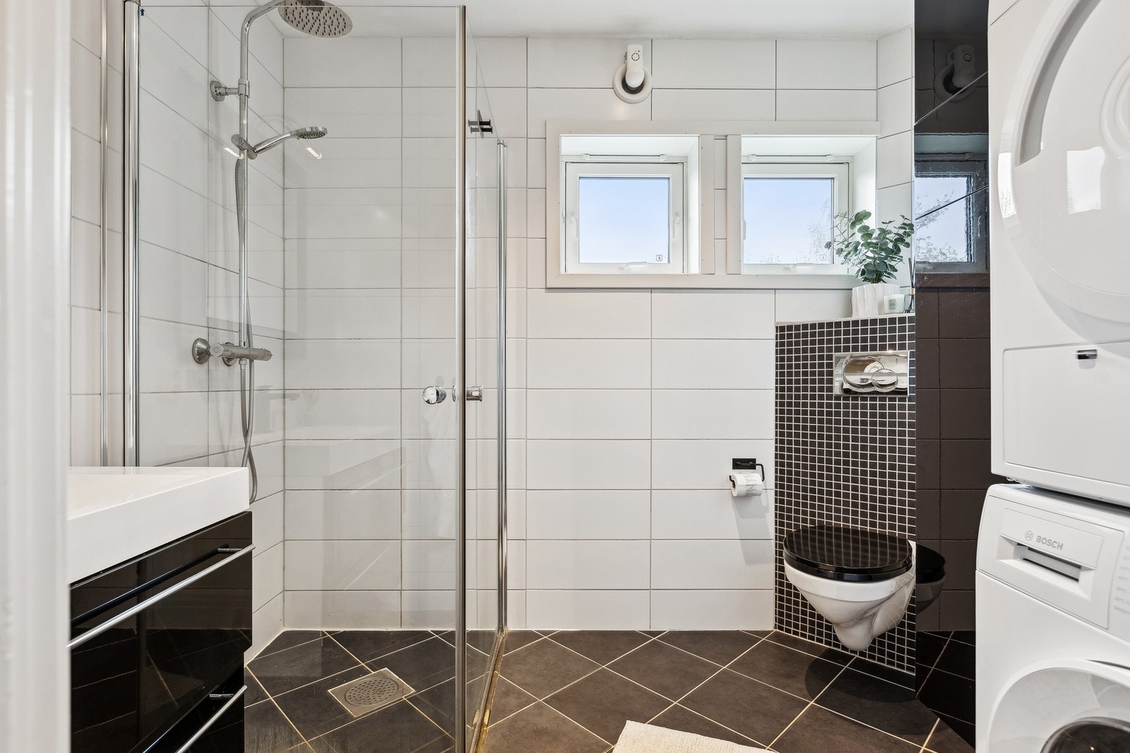Badet er utstyrt med bla. dusjhjørne, vegghengt toalett, opplegg til vaskemaskin og gulvvarme. Galleribilde