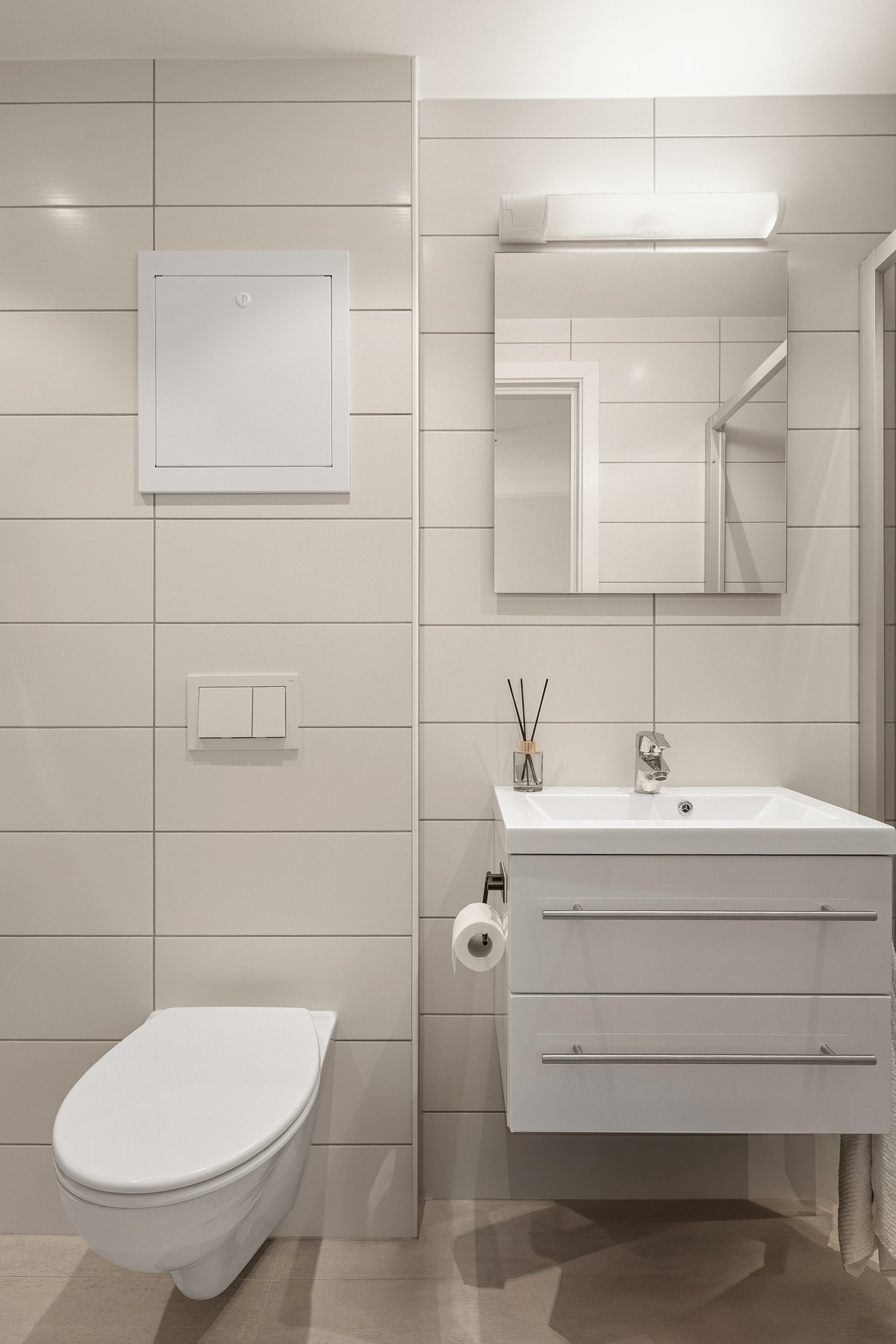 Badet er innredet med baderomsinnredning, veggehengt toalett og dusj med glassvegger. Galleribilde