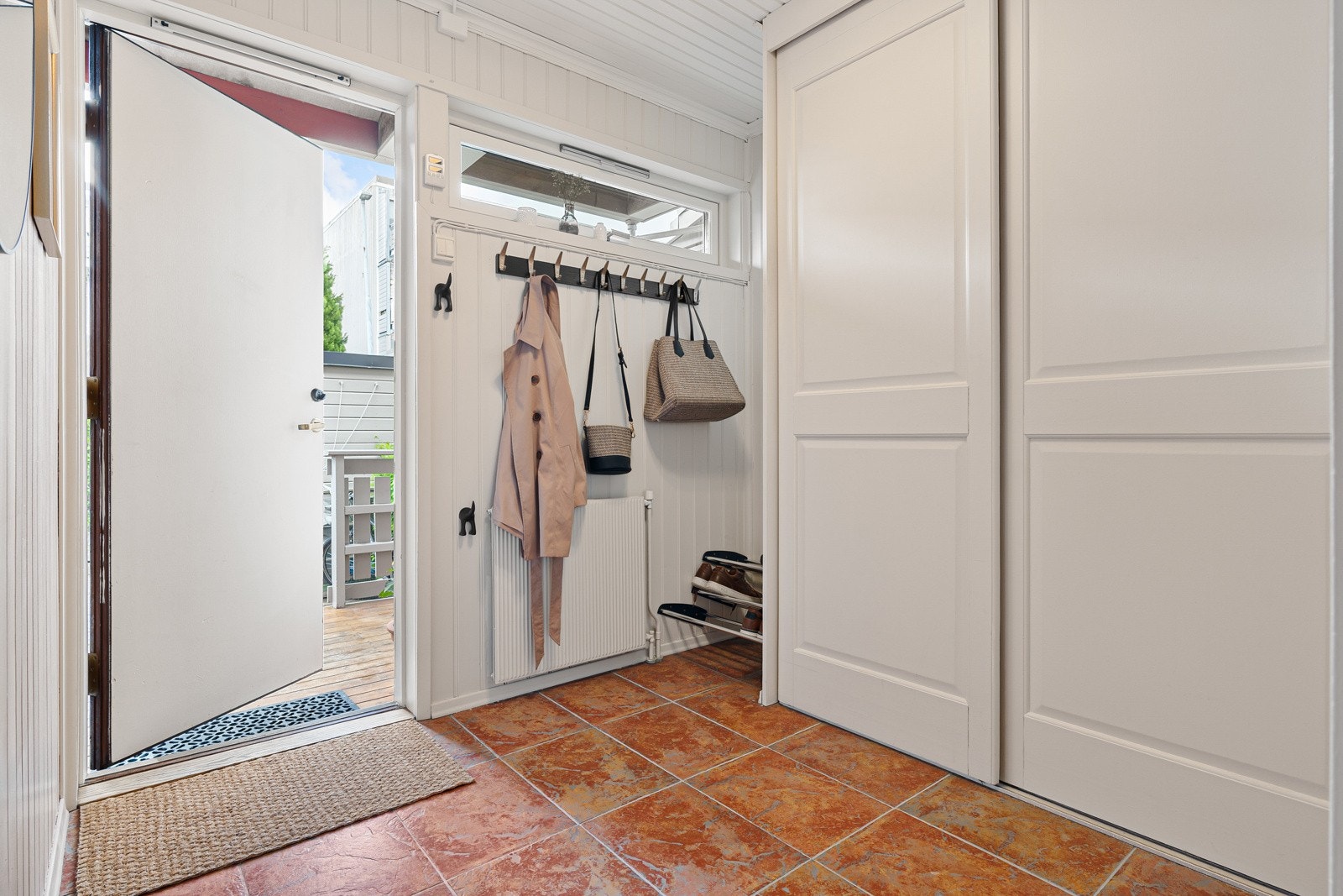 Entrèen er flislagt og innredet med en praktisk skyvedørsgarderobe som gir rikelig med oppbevaringsplass. Galleribilde