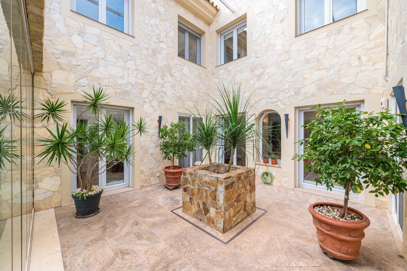 Patioen binder hjemmet sammen med lys, luft og middelhavssjarm. Galleribilde