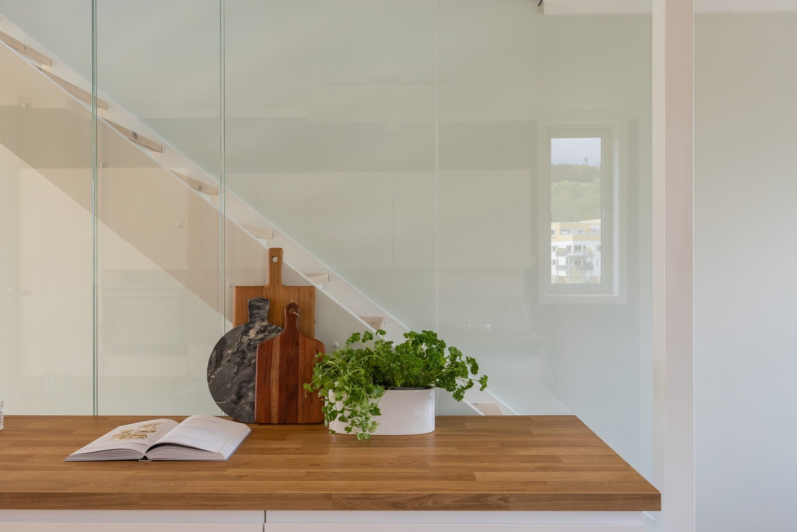 Stilfullt trappeløp kledd i glass med glassrekkverk i overetasjen. Galleribilde