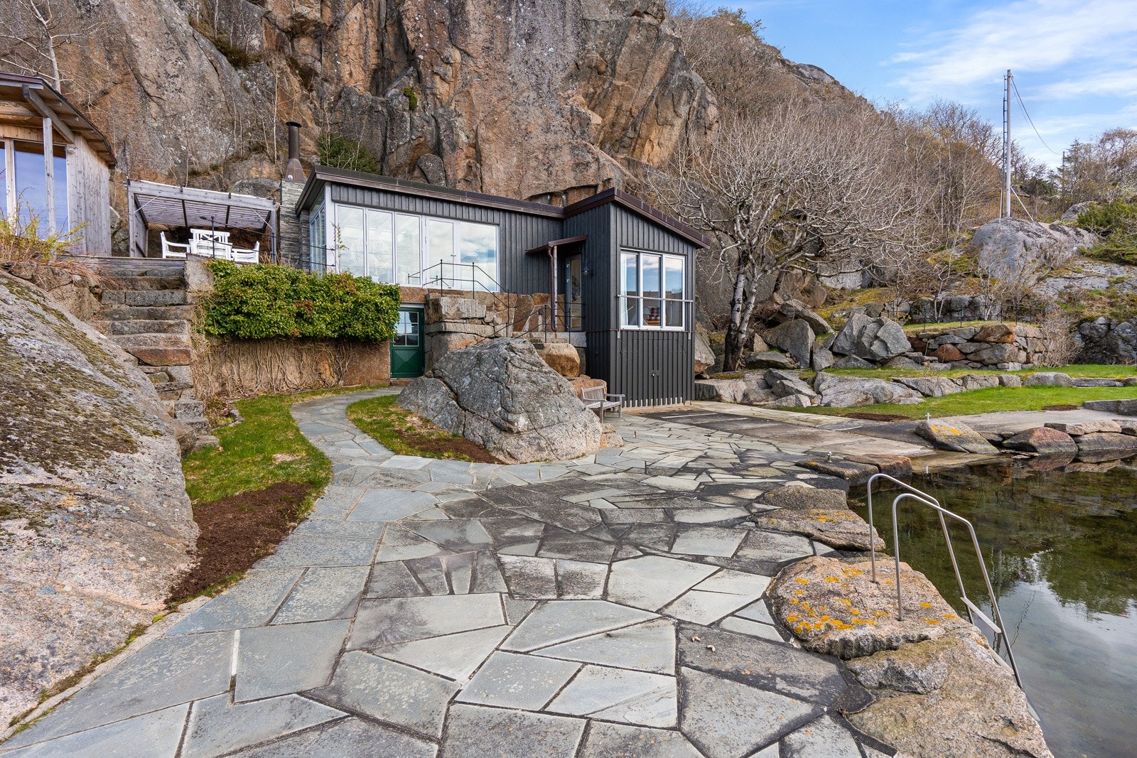 Nyere anneks (tidligere sjøbod) med nyere badstue og pergola mellom disse Galleribilde