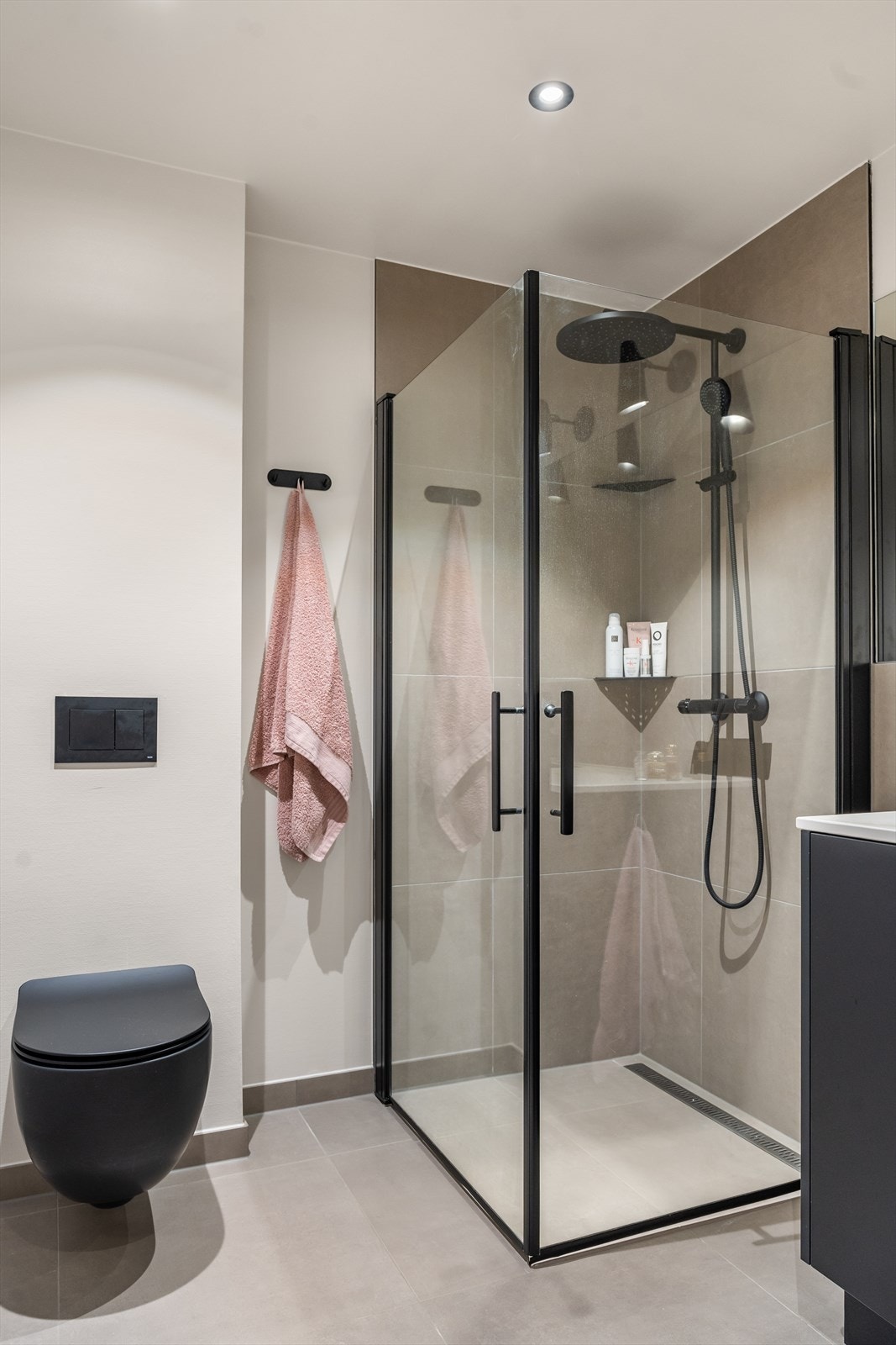 Badet har innredning med nedfelt servant, dusj, veggmontert toalett og opplegg for vaskemaskin Galleribilde