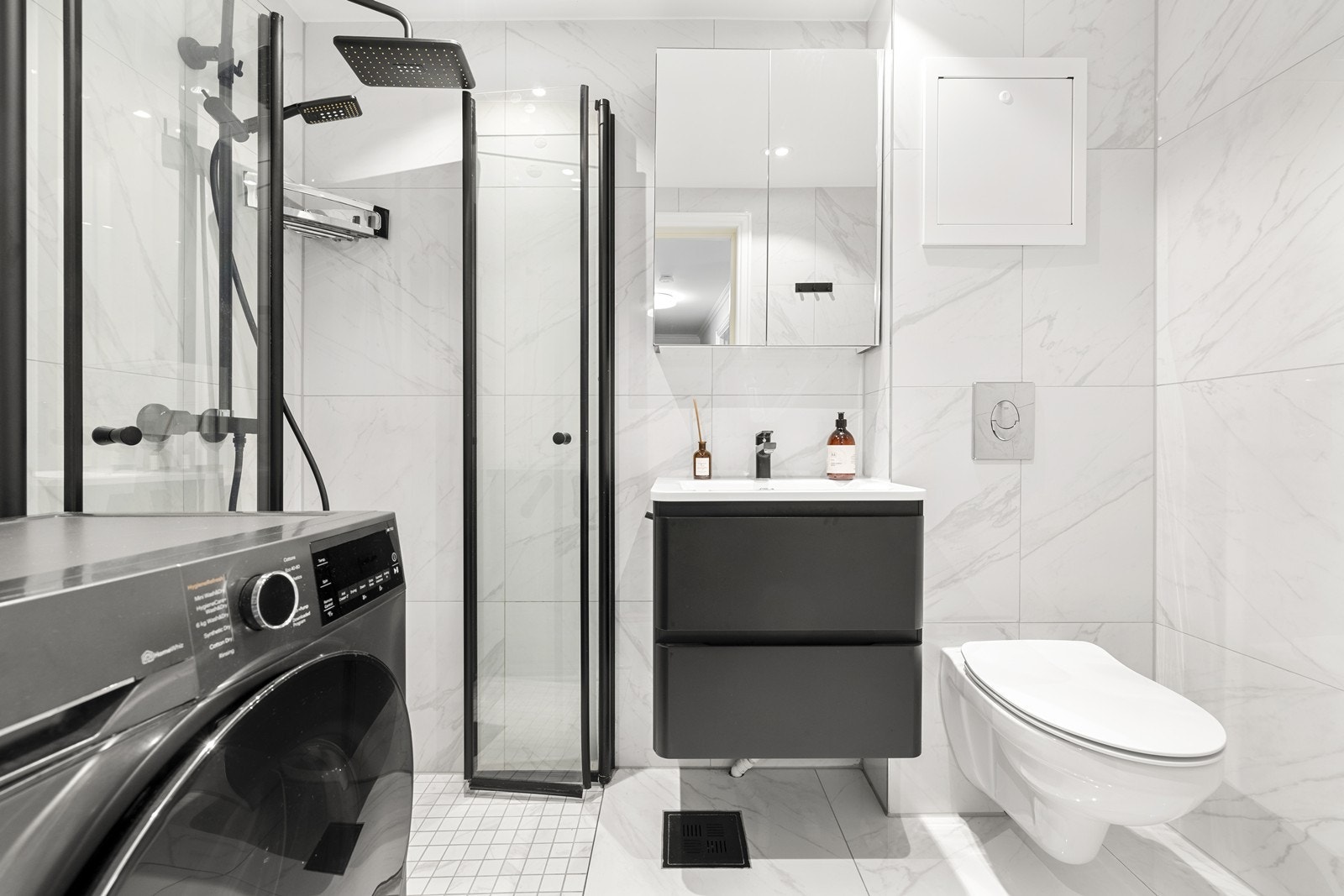 Badet er innredet med heldekkende servant, veggmonterte dusjvegger og WC, samt opplegg for vaskemaskin. Galleribilde