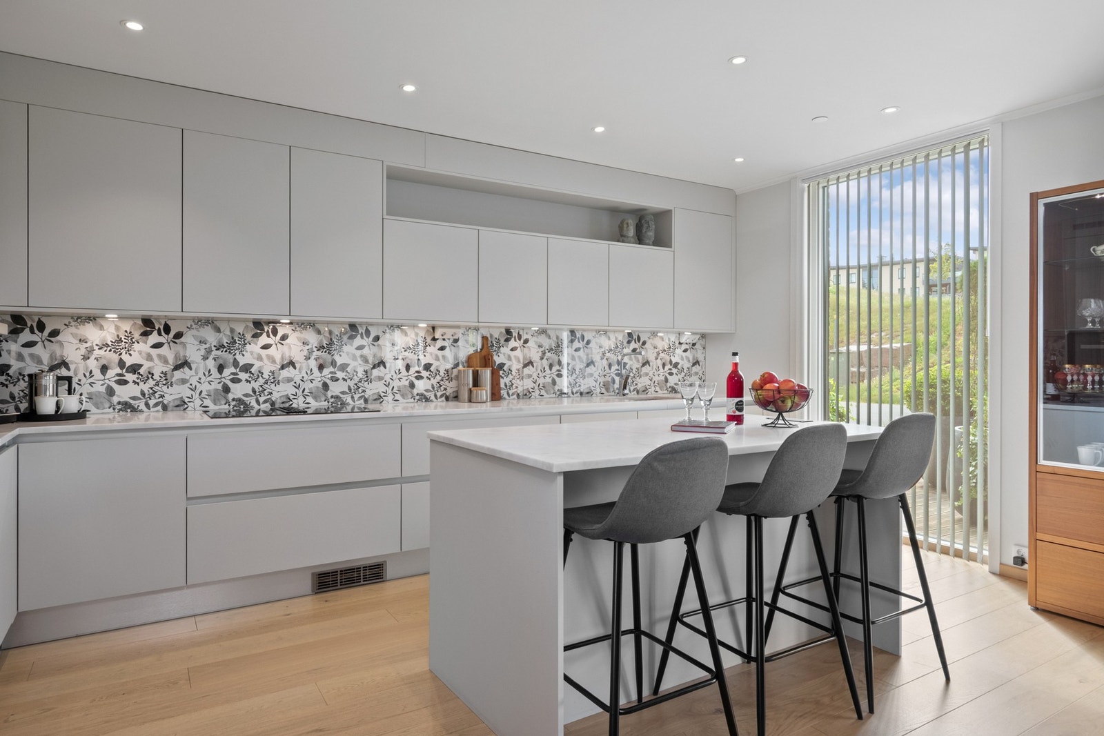 Frontene er matte og håndtaksløse, holdt i en lysegrå tone som harmonerer godt med øvrige overflater. Galleribilde