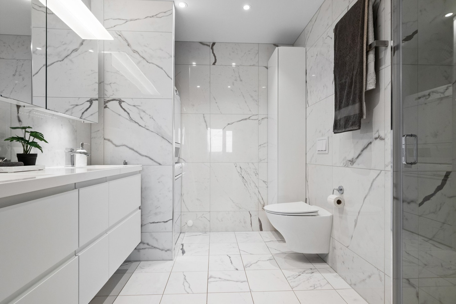 Hovedbadet er romslig og utstyrt med dusjsone, vegghengt toalett og nisje med opplegg for vaskemaskin/tørketrommel i søyleløsning. Galleribilde